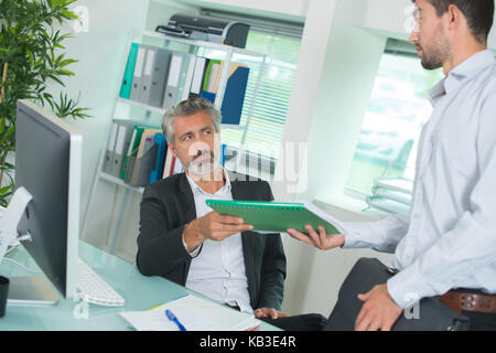 Unternehmer und Arbeitnehmer diskutieren über Dokumente im Büro Stockfoto