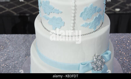 Eine mehrstufige weiße Hochzeitstorte auf einem silbernen Base und rosa Blüten an der Spitze. Veautiful Hochzeitstorte. Dicorated Kuchen für Feier oder Hochzeit. Kuchen Stockfoto