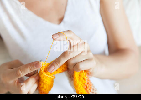 Eine Frau strickt ein farbiges Tuch. Die Hände schließen. Stockfoto