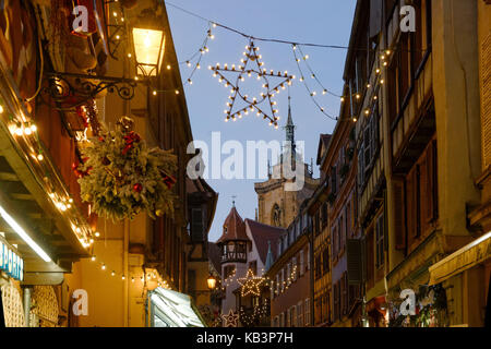 Frankreich, Haut Rhin, Colmar, Weihnachtsdekoration in der Rue des Marchands, Maison Pfister und Kirchturm der Abteikirche Saint Martin Stockfoto