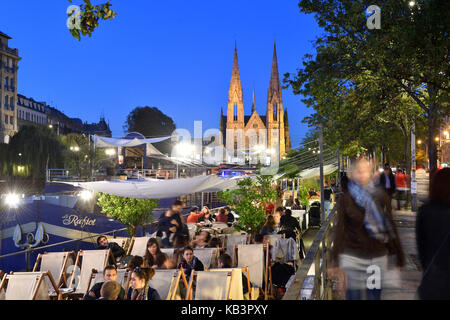 Frankreich, Bas-Rhin, Straßburg, Altstadt Weltkulturerbe der UNESCO, Cafés Boote am Quai des Bateliers an den Ufern der Ill und Saint-Paul-Kirche im Hintergrund Stockfoto