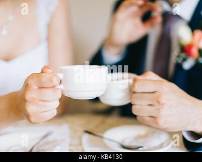 Bräutigam und Braut holding Kaffeetasse. Tassen Kaffee für Braut und Bräutigam am Hochzeitstag. Stockfoto