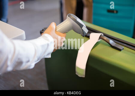 7/8 Bild der Frau scannen Tag auf Gepäck am Flughafen Check-in Stockfoto