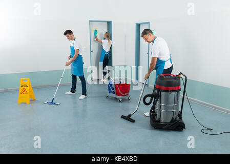 Gruppe von Hausmeister Reinigung Korridor mit Reinigung Ausrüstungen Stockfoto