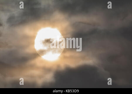 Sonne hinter Wolken in einem Nebelhaften bewölkten Tag. Stockfoto