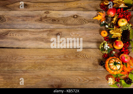 Herbst Hintergrund mit Rahmen der Kürbisse, Äpfel und goldene Blätter auf der linken Seite des rustikalen Holztisch. Thanksgiving Begrüßung mit Herbst Symbole, c Stockfoto