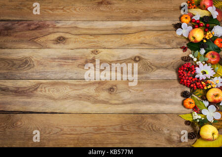 Happy Thanksgiving gruss Hintergrund mit Kürbisse, Äpfel, Beeren, Blättern und weissen Blüten auf der rechten Seite des rustikalen Holztisch, kopieren Raum Stockfoto