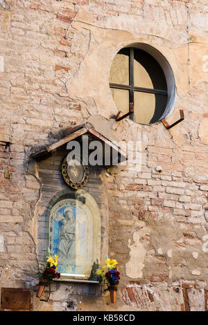 Ein Altar auf einem Backstein Haus Wand an der antiken Stadt Montalcino, Italien Stockfoto