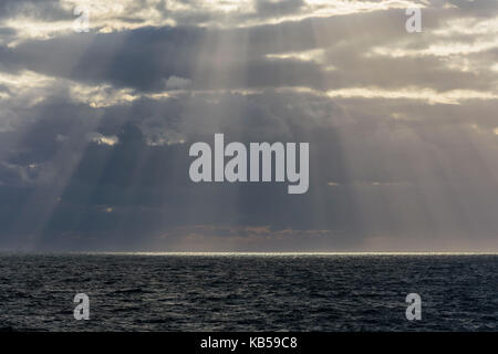 Sonne bricht durch die Wolken mit Sonnenstrahlen über See, der Nordsee, Vereinigtes Königreich Stockfoto