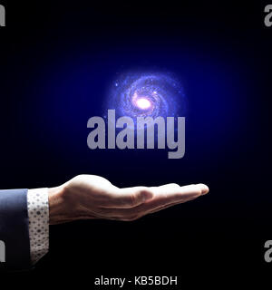 Geschäftsmann Hand kleine Galaxie. Stockfoto