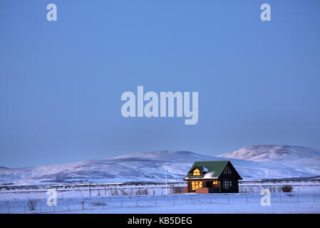 Winterlandschaft bei Dämmerung, einsame Hütte in der Abendsonne getaucht, in der Nähe des Seljalandsfoss, South Island, Polargebiete Stockfoto