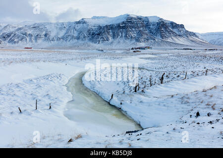Herrliche verschneite Winterlandschaft gebadet in der nachmittäglichen Sonne, auf dem Weg zur Halbinsel Snaefellsnes, Island Stockfoto