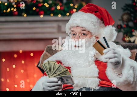 Santa mit Kreditkarten und Dollar Stockfoto