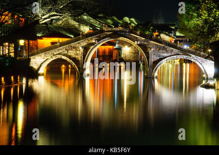 Beleuchtet Brücke mit Wasser Reflexionen am Abend Fotografie an Wuzhen in China Stockfoto