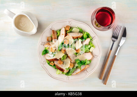 Hühnchen Caesar Salat auf hellen Hintergrund mit Wein Stockfoto