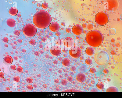 Red Oil Blasen auf blaues Wasser Stockfoto