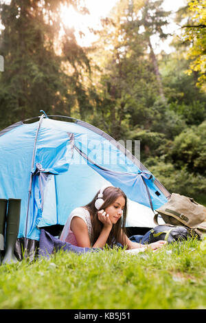 Teenage Mädchen vor Zelten im Wald. Stockfoto