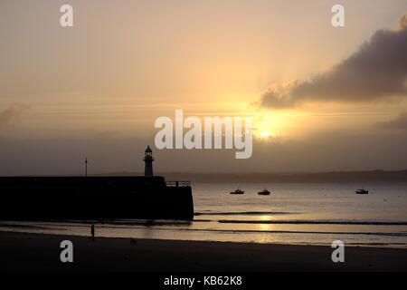 St Ives, Cornwall, UK. 29 Sep, 2017. de Wetter. Nach einer Nacht der Regen Es war ein glänzender Start in den Tag in Cornwall. Die Sonne hinter dem smeaton Leuchtturm auf der anderen Seite der Bucht steigt. Credit: Paul melling/alamy leben Nachrichten Stockfoto