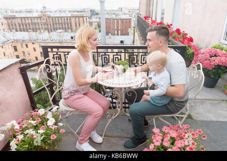 Familie Entspannen auf dem Balkon beim Trinken von Kaffee Stockfoto