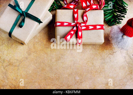 Die Gemeinkosten der rustikale Geschenke mit Herz Form und grünen Bändern, elf auf abstrakten Hintergrund. Kopieren Sie Platz. Gegenstand gegen weiche Fenster Beleuchtung erfasst. Stockfoto