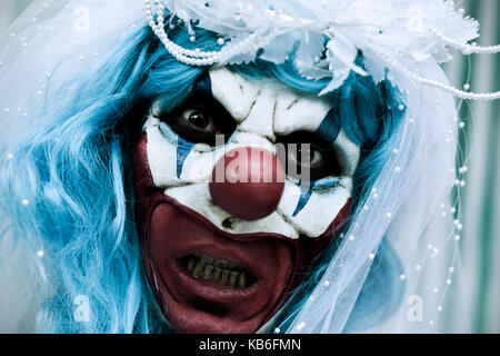 Nahaufnahme der Ein unheimlich bösen Clown tragen eine Braut Kleid, mit einem Schleier und ein Diadem Stockfoto