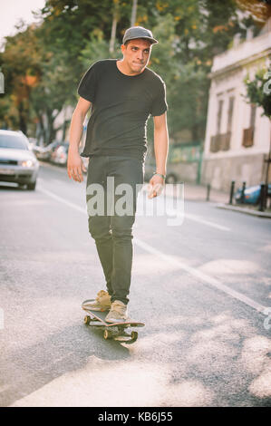 Pro Skate rider ride Skateboard vor dem Auto auf die Stadt Straße Straße durch Staus Stockfoto