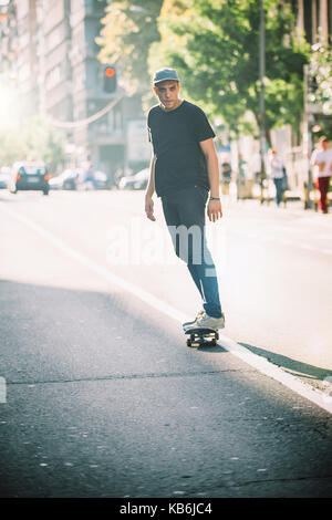 Pro Skate rider ride Skateboard vor dem Auto auf die Stadt Straße Straße durch Staus Stockfoto