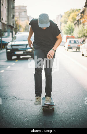 Pro Skate rider ride Skateboard vor dem Auto auf die Stadt Straße Straße durch Staus Stockfoto