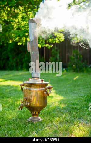 Die traditionellen russischen Samowar Heizung und kochendem Wasser in einen Sommergarten Stockfoto