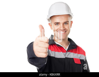 Portrait der junge lächelnde Techniker mit dem Daumen oben auf weißem Hintergrund Stockfoto