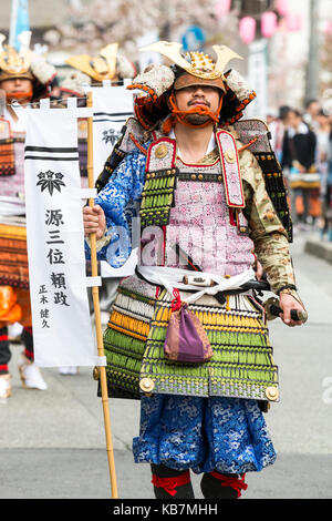 Genji Parade, jährliche Prozession durch die Straßen von Tada, Japan. Mann in Samurai Rüstung, die Fahne, die Parade der anderen Samurai Warriors. Stockfoto