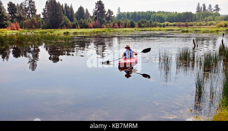 Mann ein Kajak paddeln auf einem kleinen Bergsee in zentralen Oregon Stockfoto