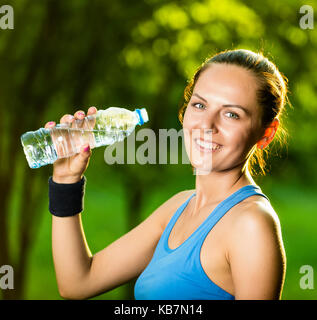 Junge Frau Trinkwasser nach dem Fitness Training Stockfoto
