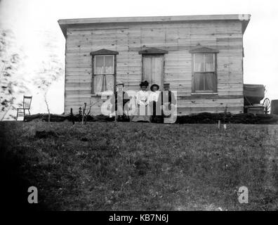 AJAXNETPHOTO. 1903. Kanada, genaue Lage unbekannt. - Gruppe posieren FÜR DIE KAMERA VOR EINEM HOLZHAUS. Fotograf: unbekannt © DIGITAL IMAGE COPYRIGHT AJAX VINTAGE BILDARCHIV QUELLE: AJAX VINTAGE BILDARCHIV SAMMLUNG REF: AVL 1973 Stockfoto