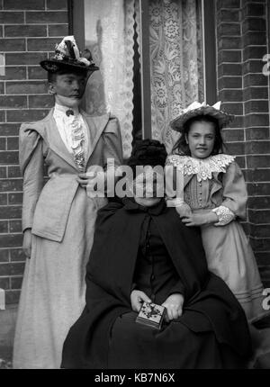 AJAXNETPHOTO. 1890 - 1914 (ca.). Ort unbekannt. - Drei Generationen von Frauen posieren FÜR DIE KAMERA AUSSERHALB EINER BACKSTEIN HAUS MIT GARDINEN IN EINEM FENSTER. Fotograf: unbekannt © DIGITAL IMAGE COPYRIGHT AJAX VINTAGE BILDARCHIV QUELLE: AJAX VINTAGE BILDARCHIV SAMMLUNG REF: AVL 172109 1574 Stockfoto