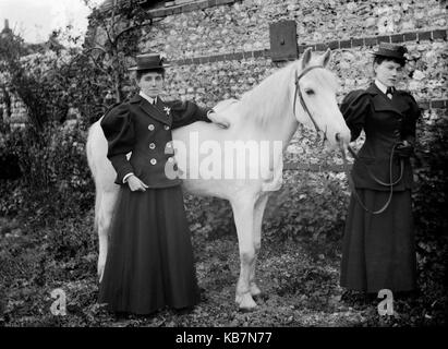 AJAXNETPHOTO. 1890 - 1914 (ca.). Ort unbekannt. - Zwei gut gekleidete Damen MIT EINEM WEISSEN PFERD POSIEREN FÜR DIE KAMERA VOR EINEM aus Stein gebauten Gebäude. Fotograf: unbekannt © DIGITAL IMAGE COPYRIGHT AJAX VINTAGE BILDARCHIV QUELLE: AJAX VINTAGE BILDARCHIV SAMMLUNG REF: AVL 172109 8 Stockfoto