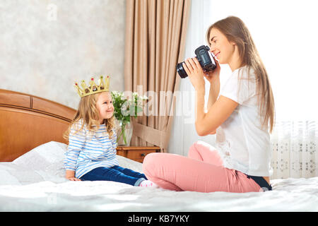 Mama nimmt Bilder von Ihrem Kind in einem Zimmer. Stockfoto