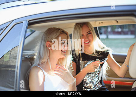 Die hübsche europäische Mädchen 25-30 Jahre alt im Auto Foto machen auf dem Mobiltelefon Stockfoto