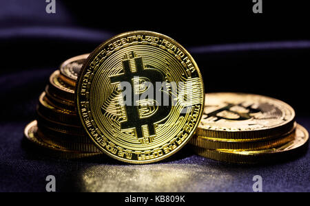 Golden glänzenden Bitcoins auf schwarzem Hintergrund gestapelt Stockfoto