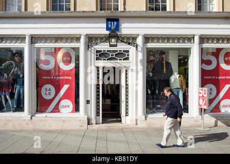 Ein Mann wird dargestellt, wie er letzten Spaziergänge Vergangenheit eine Lücke mode bekleidung shop Front auf der High Street in Bath, Somerset, England, Großbritannien Stockfoto