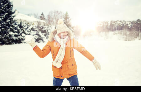 glücklich Jüngling spielen Schneebälle im winter Stockfoto