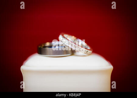 Wunderschöne Diamond Wedding Ring Set auf der eigenen weißen Jewel Box mit rotem Hintergrund dargestellt. Stockfoto