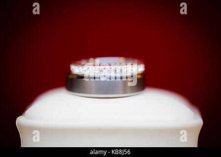 Wunderschöne Diamond Wedding Ring Set auf der eigenen weißen Jewel Box mit rotem Hintergrund dargestellt. Stockfoto