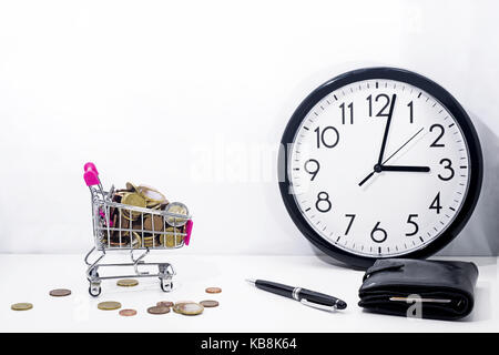 Abstrakte Komposition von etwas zu kaufen. Kleine Wagen mit Münzen auf weißem Hintergrund. Stockfoto