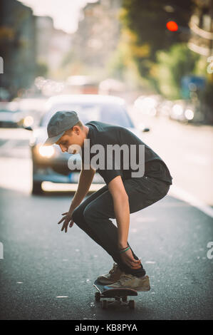 Pro Skate rider ride Skateboard vor dem Auto auf die Stadt Straße Straße durch Staus Stockfoto