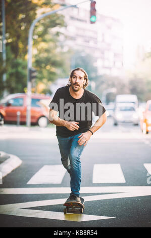 Pro Skate rider ride Skateboard vor dem Auto auf die Stadt Straße Straße durch Staus Stockfoto