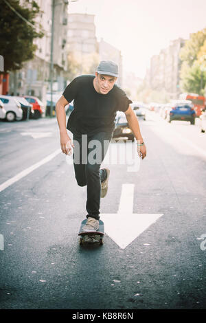 Pro Skate rider ride Skateboard vor dem Auto auf die Stadt Straße Straße durch Staus Stockfoto