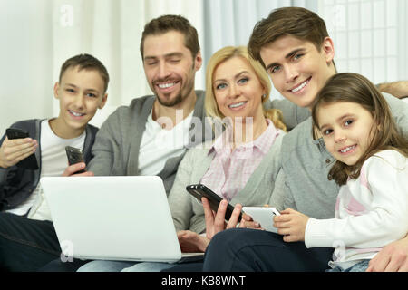 Familie sitzt auf der Couch mit Laptop Stockfoto