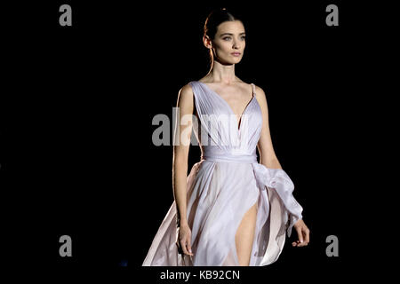 Isolierte brunette Modell mit lila Kleid in Hannibal Laguna Sammlung Mercedes-Benz Fashion Week 2017. Stockfoto