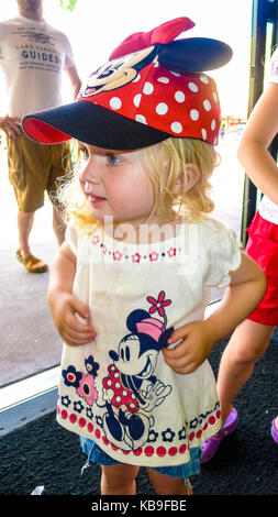 Kleinkind Tragen eines Minnie Mouse T-Shirt und Mütze mit Ohren in roten und weißen Tupfen in Disney World, Florida, USA Stockfoto